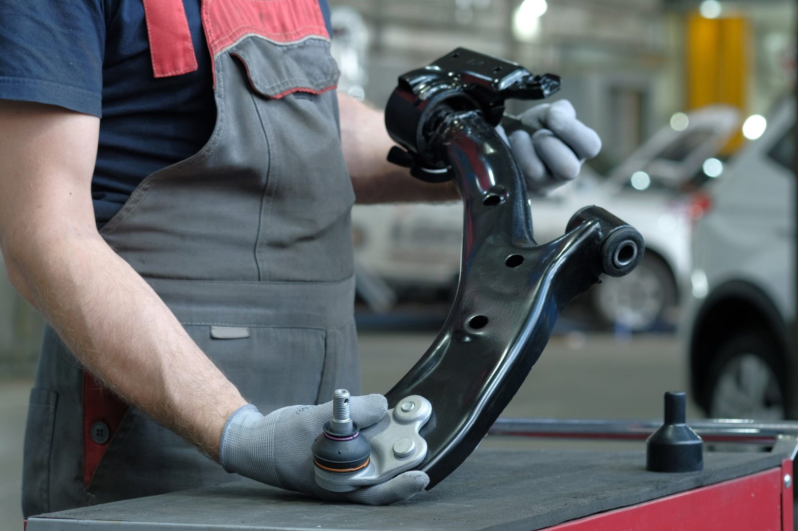 Car,Repair,At,The,Service,Center.,An,Auto,Mechanic,Holds car suspension repair